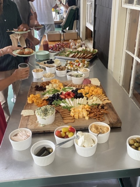 Hand-built grazing board with cheeses, charcuterie, fresh fruit, olives, dips, and crackers served at a Camp Wigwam wedding cocktail hour