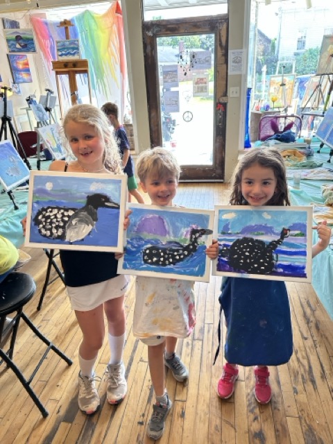 Three Little Loons proudly showing off their painted loon artwork from a field trip to a paint studio